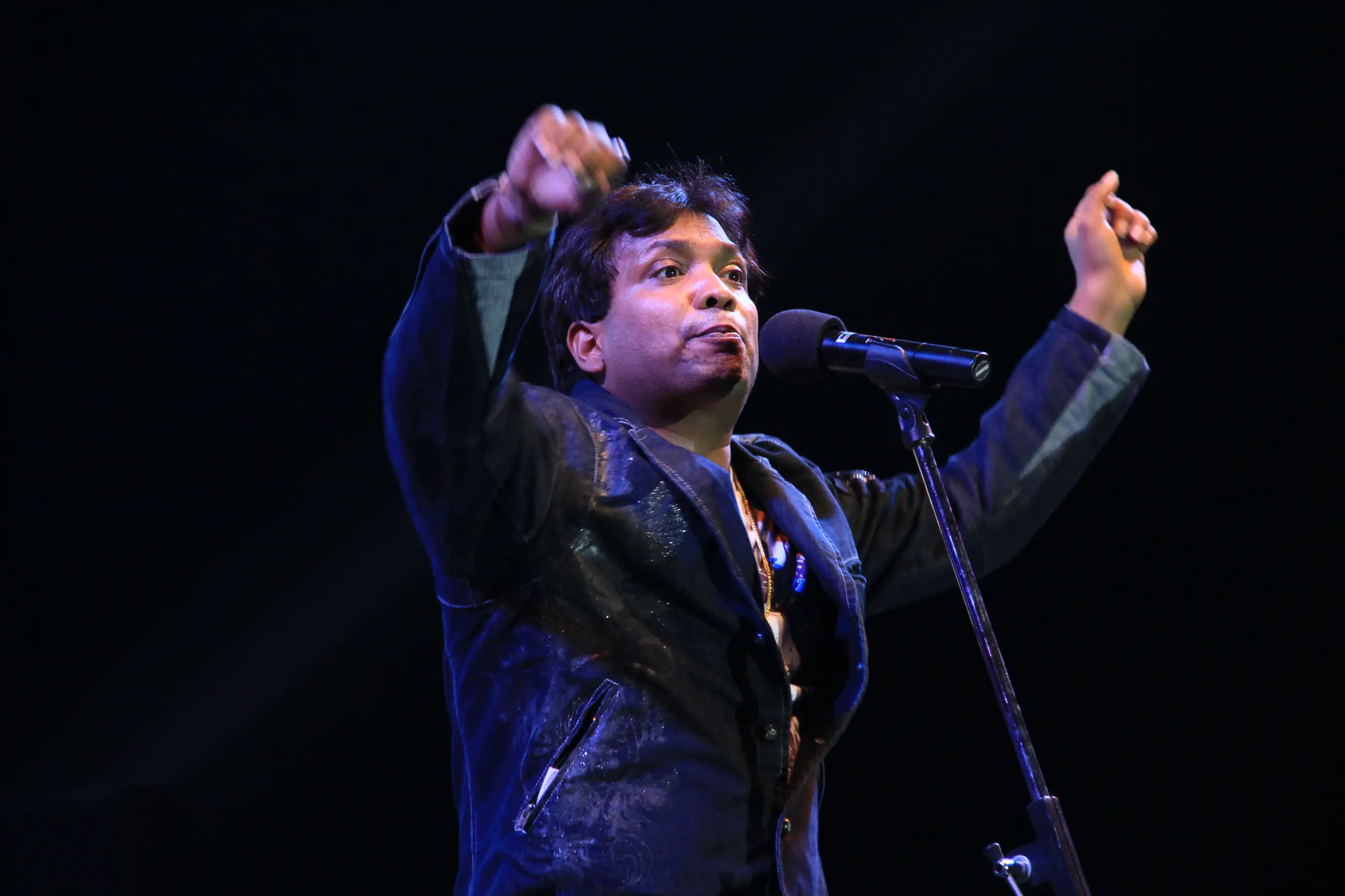 Balloon arch in orange, black, and white colors framing an ITT logo board lit with warm lights